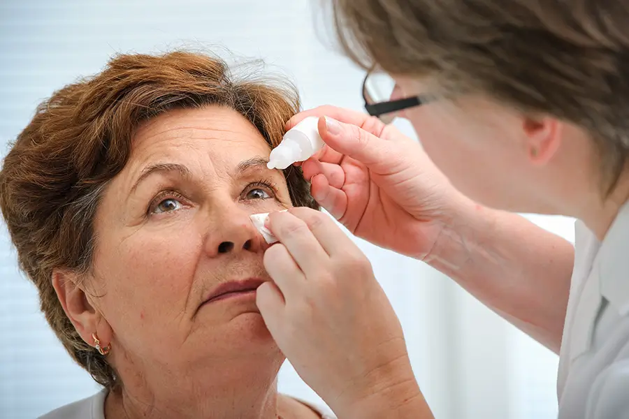 optometrist giving eye drops to a patient for dry eyes